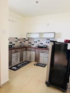 a kitchen with a refrigerator in the middle of a room at The Hampiness Studio 2 in Hospet