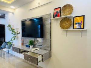 a living room with a tv on a wall at The Hampiness Studio 2 in Hospet