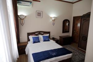 a bedroom with a bed with blue pillows at Golubie Kupola Hotel 华人酒店 in Bukhara