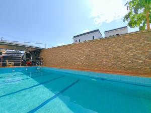 a brick wall next to a swimming pool at Aotel Hotel Lagos Ago in Lagos