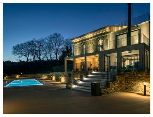 a house with a swimming pool in front of it at Torre Zambra RESORT in Villamagna