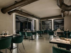 a restaurant with green chairs and tables and windows at Torre Zambra RESORT in Villamagna