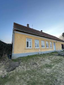 a yellow house with windows on top of a field at Villa Katry in Augustenborg