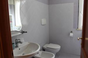 a white bathroom with a sink and a toilet at Agrimar 2 in Rignano Flaminio