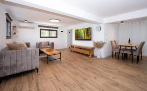 a living room with a couch and a table at לב המעיין- סוויטה מושלמת עם ג'קוזי במושב פסטורלי in Reẖov