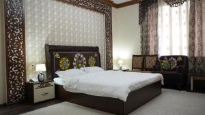 a bedroom with a large bed and a chair at Hepci Hotel Istaravshan in Ŭroteppa +18 photos