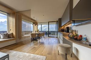a kitchen and living room with a table and chairs at Luxury Dolomites Apartments in Dobbiaco