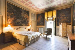 a bedroom with a bed and a painting on the wall at Palazzo Guicciardi in San Bernardo