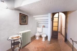 a bathroom with a toilet and a table at Palazzo Guicciardi in San Bernardo +31 photos