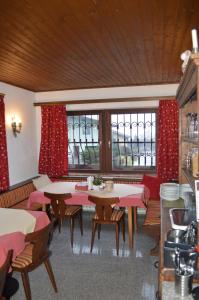 a restaurant with tables and chairs and red curtains at Haus Susanne in Radstadt