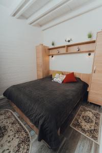 a bedroom with a bed with a black comforter at Fanarele din Hangu in Hangul