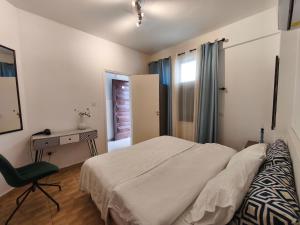 a bedroom with a bed and a desk and a chair at Queens gardens in Paphos +32 photos