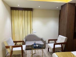 a room with a couch and chairs and a table at hotel shree palace in Ratlām