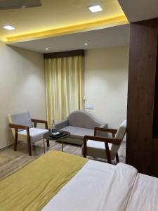 a room with a bed and a couch and a table at hotel shree palace in Ratlām