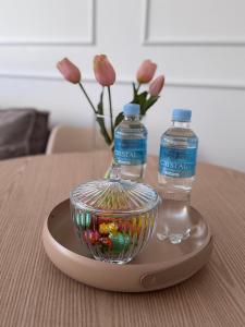 a glass bowl and two bottles of water on a table at Apartament pod Ratuszem - Kluczbork in Kluczbork