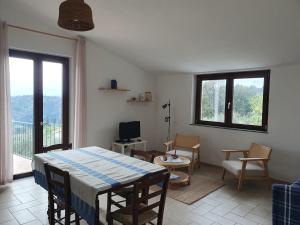 a living room with a table and chairs and a balcony at Il Grottino di Sarzana in Sarzana