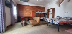 a bedroom with a bed and a chair and a table at Résidence abdou diouf in Dakar
