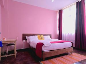 a bedroom with a bed and a desk and a window at Triple SSS Hotel in Nairobi