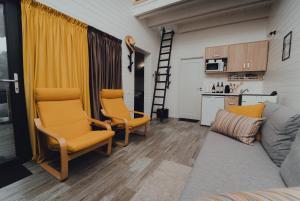 a living room with a couch and two chairs and a kitchen at Fanarele din Hangu in Hangul