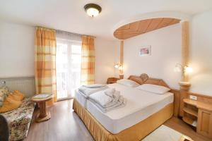 a bedroom with a large bed and a window at Albergo al Cervo - Gasthof zum Hirschen in Lagundo +50 photos