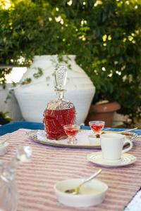 a table with a bottle and two cups on it at Lagos House Α in Kámpos