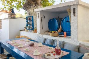 a blue table with plates and cups on a patio at Lagos House Α in Kámpos
