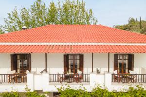 an orange roofed house with tables and chairs at Lagos House Α in Kámpos