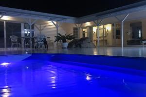 a swimming pool lit up at night in a house at The Seaside View in Simonʼs Town