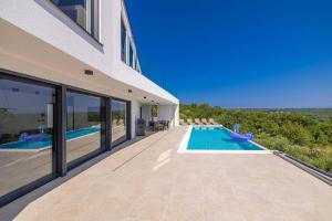Außenansicht eines Hauses mit Swimmingpool in der Unterkunft Villa ELEVATION in Vrh