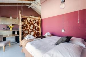 a bedroom with a large bed and pink walls at Agriturismo CasaMatilda in Dogliani