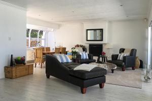 a living room with two couches and a table at The Seaside View in Simonʼs Town