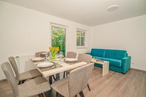a dining room with a table and a blue couch at BSW Ferienwohnungen Hiddensee in Hiddensee +31 photos