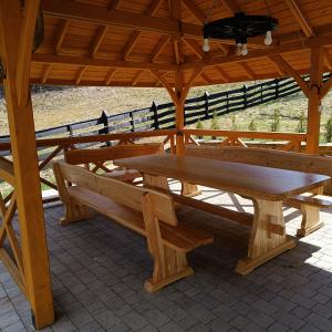 a wooden picnic table and benches in a pavilion at Dom na Krzemienicy in Izdebki