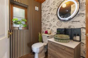 a bathroom with a toilet and a mirror on the wall at Bay View - holiday cottage by the sea with stunning views in Pendine +19 photos