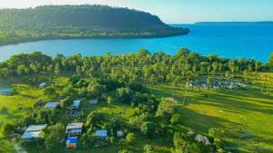 an aerial view of a field and a lake at Port Olry BBQ Table and Camping Side in Port-Olry +36 photos