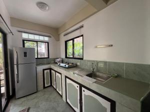 a kitchen with a sink and a refrigerator at Boracay Garden Retreat in Boracay