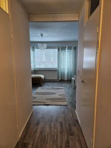 an empty living room with a large window and a hallway at Rivitaloyksiö Vilppulassa in Vilppula