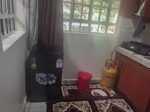 a small kitchen with a black refrigerator and a rug at Kismet Hideaway in Nairobi