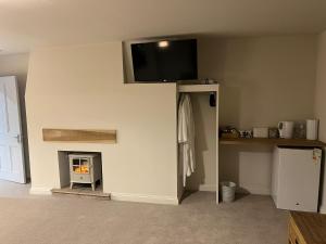 a living room with a fireplace and a tv on the wall at Stillington Retreat in Stillington