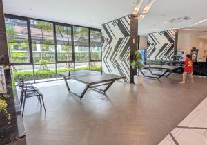 a woman standing in a room with a table at Amazing High Floor Luxury Studio in Sathani Ban Hua Mak