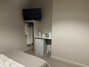 a bedroom with a bed and a tv on the wall at Stillington Retreat in Stillington