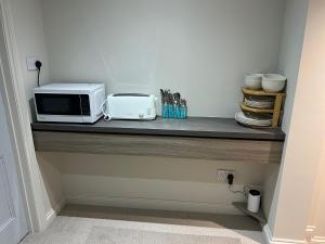 a counter with a microwave and a toaster oven on it at Stillington Retreat in Stillington