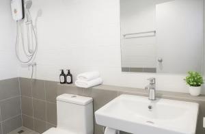 a bathroom with a toilet and a sink and a mirror at Amazing High Floor Luxury Studio in Sathani Ban Hua Mak +19 photos