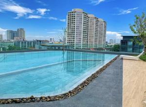 a large swimming pool with a city skyline in the background at Amazing High Floor Luxury Studio in Sathani Ban Hua Mak