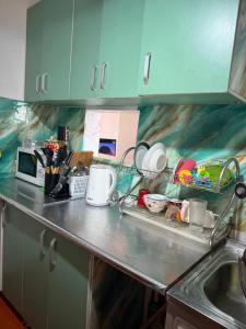 a kitchen counter with dishes in the dish racks at Baburs guest house in Orgochor