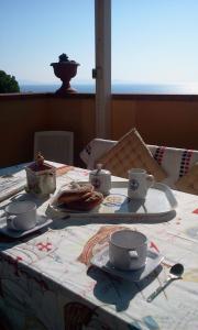 a table with cups and saucers on top at Magic View in Tuscany in Capo D'Arco