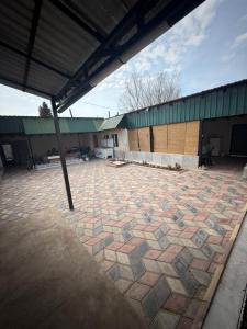 a building with a large courtyard with a stone floor at Baburs guest house in Orgochor