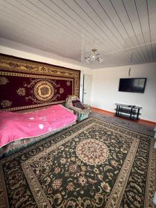 a bedroom with a large bed and a rug at Baburs guest house in Orgochor