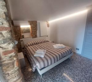 a bedroom with a bed with two towels on it at Affittacamere il Gallo Panoramico - Alpine Trekking Stay in Donato