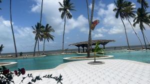 a swimming pool with palm trees on the beach at Antonio Beach in Uroa